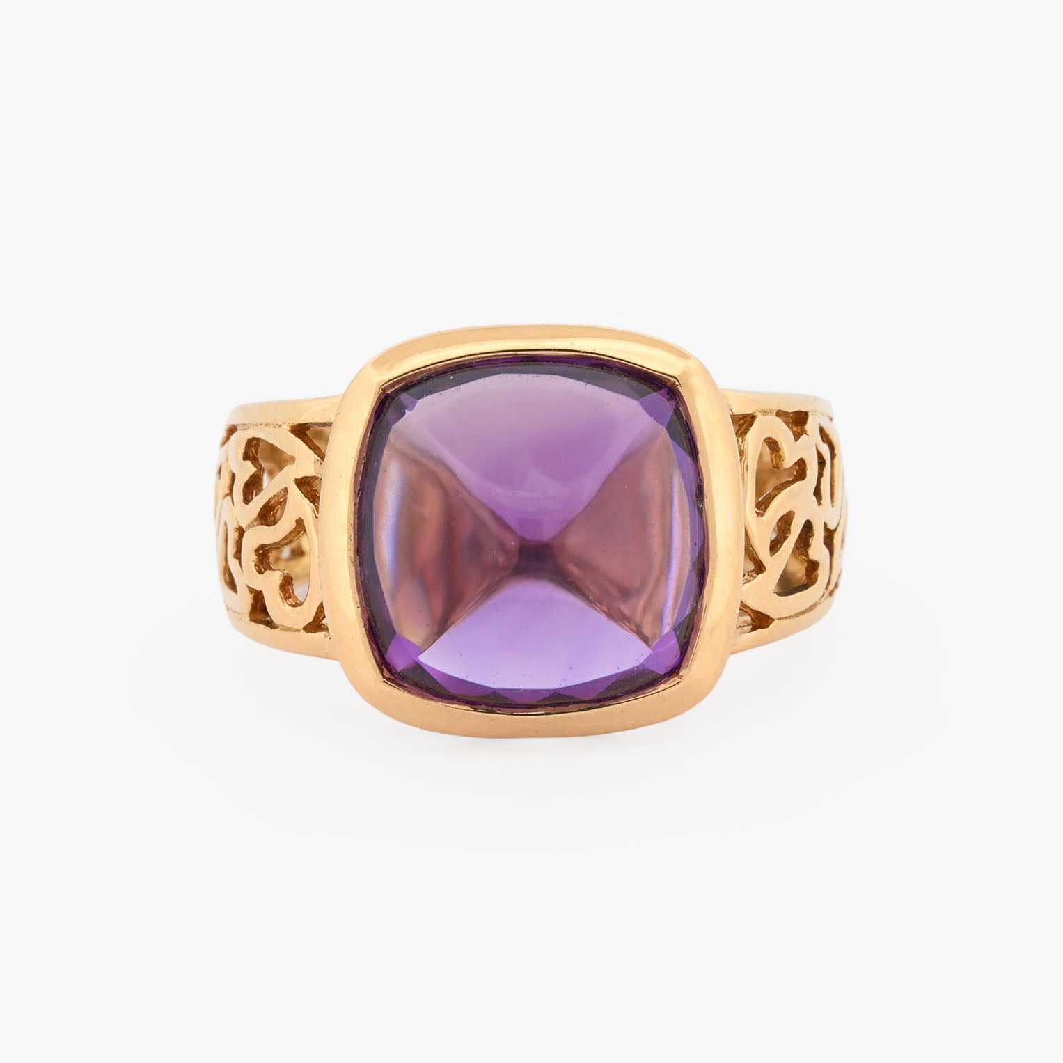 Comprar anillo ancho de oro amarillo de 18kt y amatista cabujon en forma de piramide, montada en un aro semicalado con formas de corazon. 