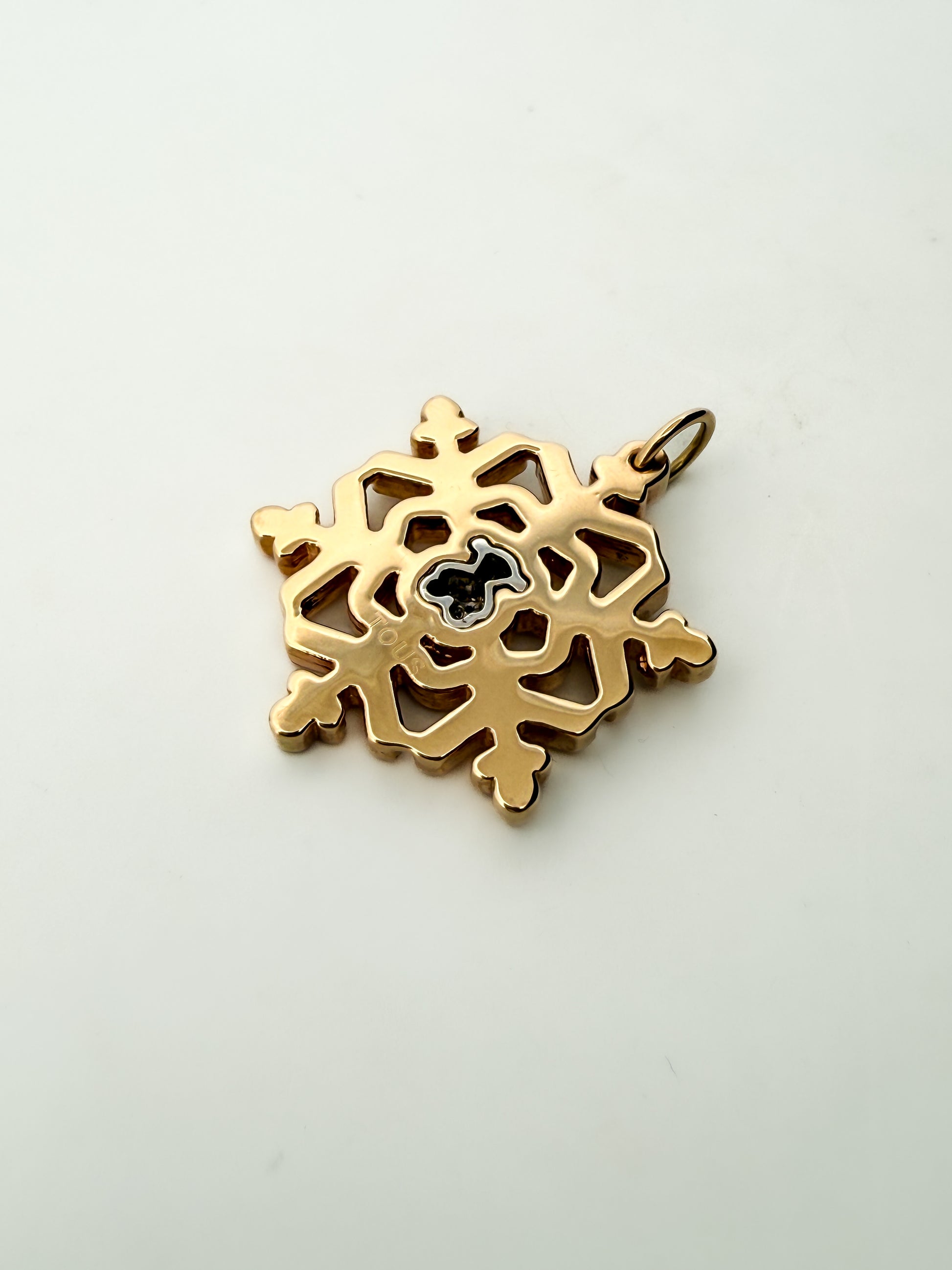 Colgante de la firma TOUS realizado en oro amarillo y blanco de 18kt en forma de copo de nieve y oso en la parte central con pavé de de diamantes. Joyas Tous.

