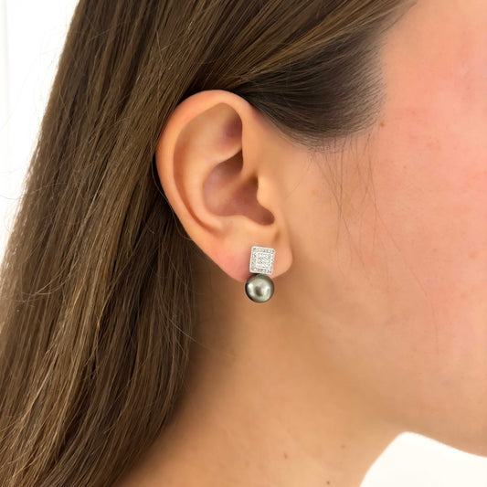 Comprar pendientes tu y yo de oro blanco de 18kt con pavé cuadrado de diamantes talla brillante y perla negra. Estos pendientes tienen la particularidad de poder usarse de dos formas distintas, con perla o sin perla. Cierre a presión. Comprar pendientes segunda mano en barcelona. Comprar oro en Barcelona. Restauración de joyas en Barcelona.