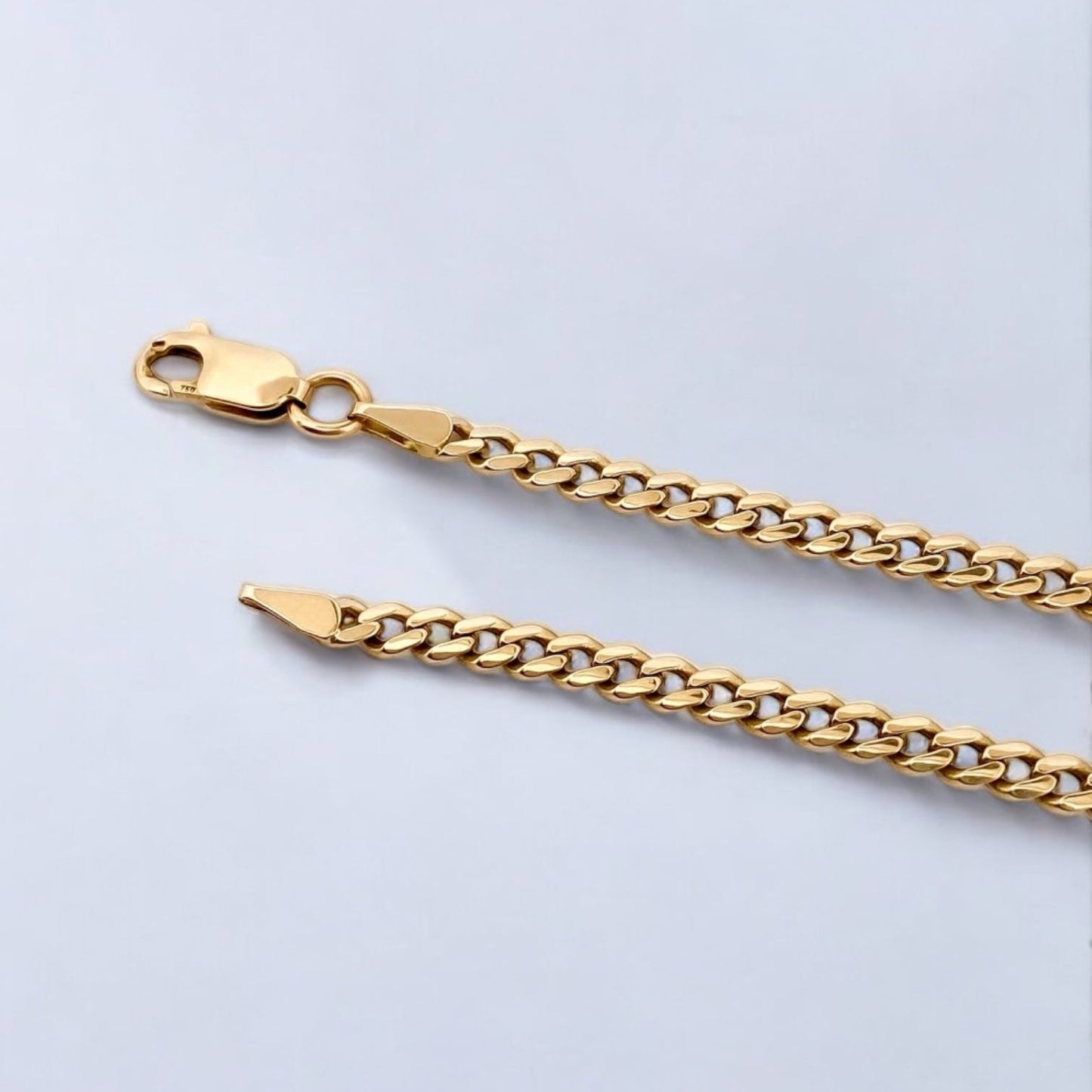 Cadena realizada en oro amarillo de 18kt con cadena barbada tipo cubana plana. Medida: 65cm de largo y cierre tipo reasa. Joya unisex. Envío gratis.