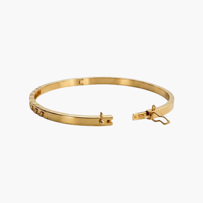 Comprar pulsera esclava de oro amarillo de 18kt con detalles en un lateral de la pulsera. Esta preciosa pulsera rígida dispone de cierre de cajón con brazo de seguridad. Esclavas de oro al mejor precio. Joyería Ian'Or.