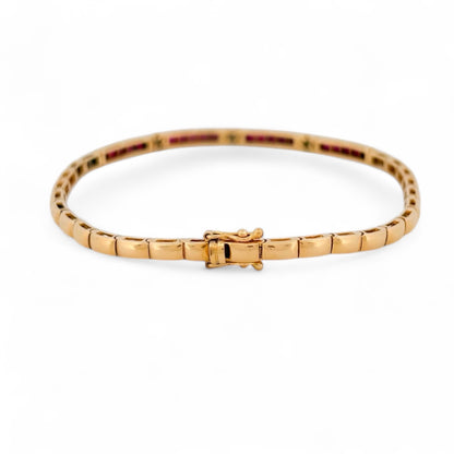 Pulsera semirígida de oro amarillo de 18kt con 20 rubíes talla princesa y 15 diamantes talla brillante. Esta preciosa pulsera dispone de cierre cajón y doble cierre de seguridad. Pesa 10,51g y mide 19,8cm. Joyas de segunda mano en Barcelona, compro oro y joyas al mejor precio. Joyería Compro Oro Barcelona, el mejor precio por tu oro y por joyas de segunda mano.