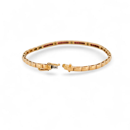 Pulsera semirígida de oro amarillo de 18kt con 20 rubíes talla princesa y 15 diamantes talla brillante. Esta preciosa pulsera dispone de cierre cajón y doble cierre de seguridad. Pesa 10,51g y mide 19,8cm. Joyas de segunda mano en Barcelona, compro oro y joyas al mejor precio. Joyería Compro Oro Barcelona, el mejor precio por tu oro y por joyas de segunda mano.