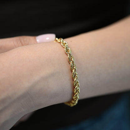 Comprar Pulsera de cordón de oro amarillo de 18kt de 19,5 cm de largo caracterizada por su diseño trenzado en espiral y un cierre de mosquetón. Pulseras de oro 18kt al mejor precio en Barcelona.