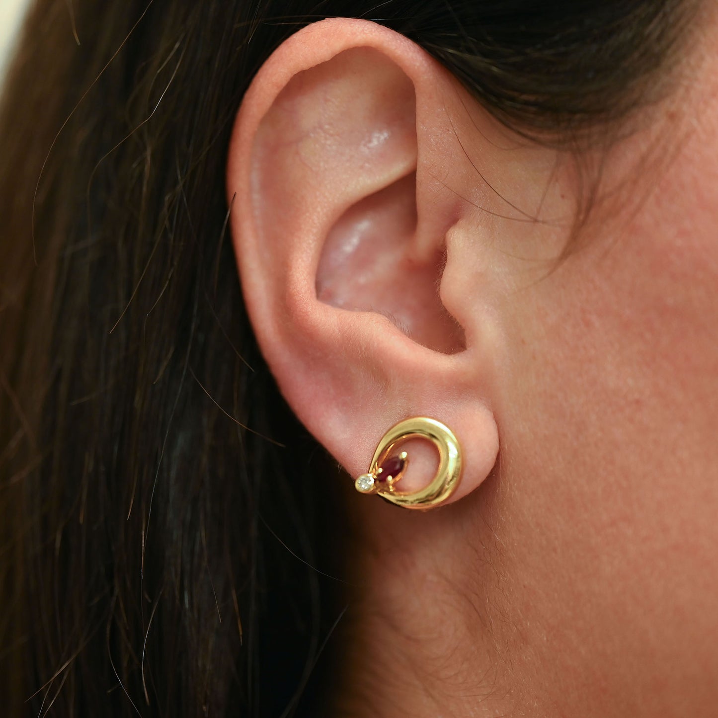 Pendientes de silueta curva entrelazada con cierre Omega de oro amarillo 18kt con rubí central y diamantes. Joyas de segunda mano restauradas y envío gratis.