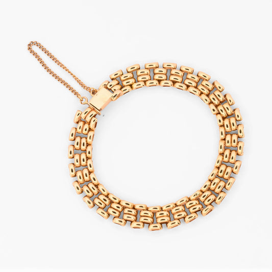 Pulsera tipo malla de oro amarillo 18 kt con un robusto diseño de cuatro filas de eslabones articulados, complementada con una cadena de seguridad. Envío gratis