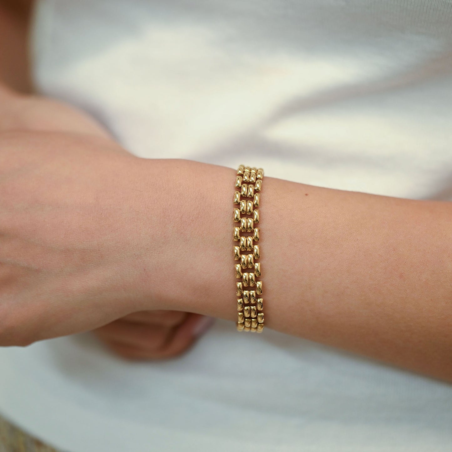 Pulsera tipo malla de oro amarillo 18 kt con un robusto diseño de cuatro filas de eslabones articulados, complementada con una cadena de seguridad. Envío gratis