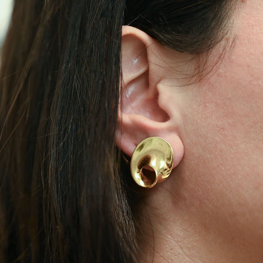 Pendientes de la marca Caparros de diseño escultural curvo con silueta calada de oro amarillo 18kt. Estos pendientes disponen de cierre tipo omega. Envío GRATIS