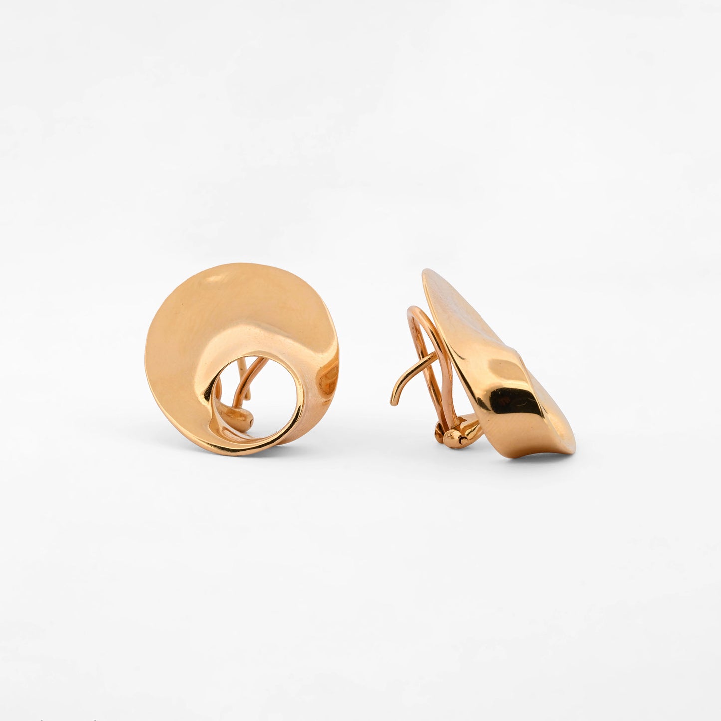 Pendientes de la marca Caparros de diseño escultural curvo con silueta calada de oro amarillo 18kt. Estos pendientes disponen de cierre tipo omega. Envío GRATIS