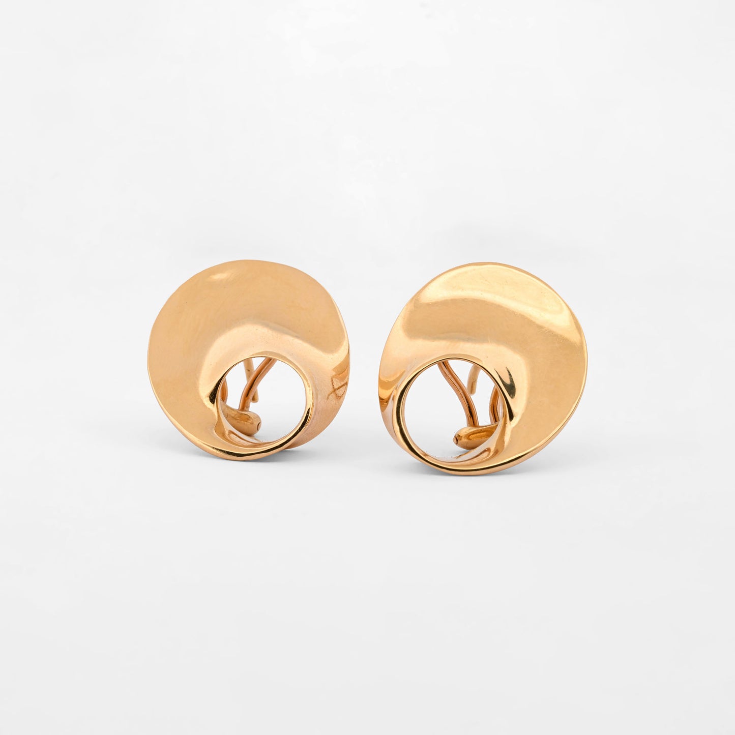 Pendientes de la marca Caparros de diseño escultural curvo con silueta calada de oro amarillo 18kt. Estos pendientes disponen de cierre tipo omega. Envío GRATIS