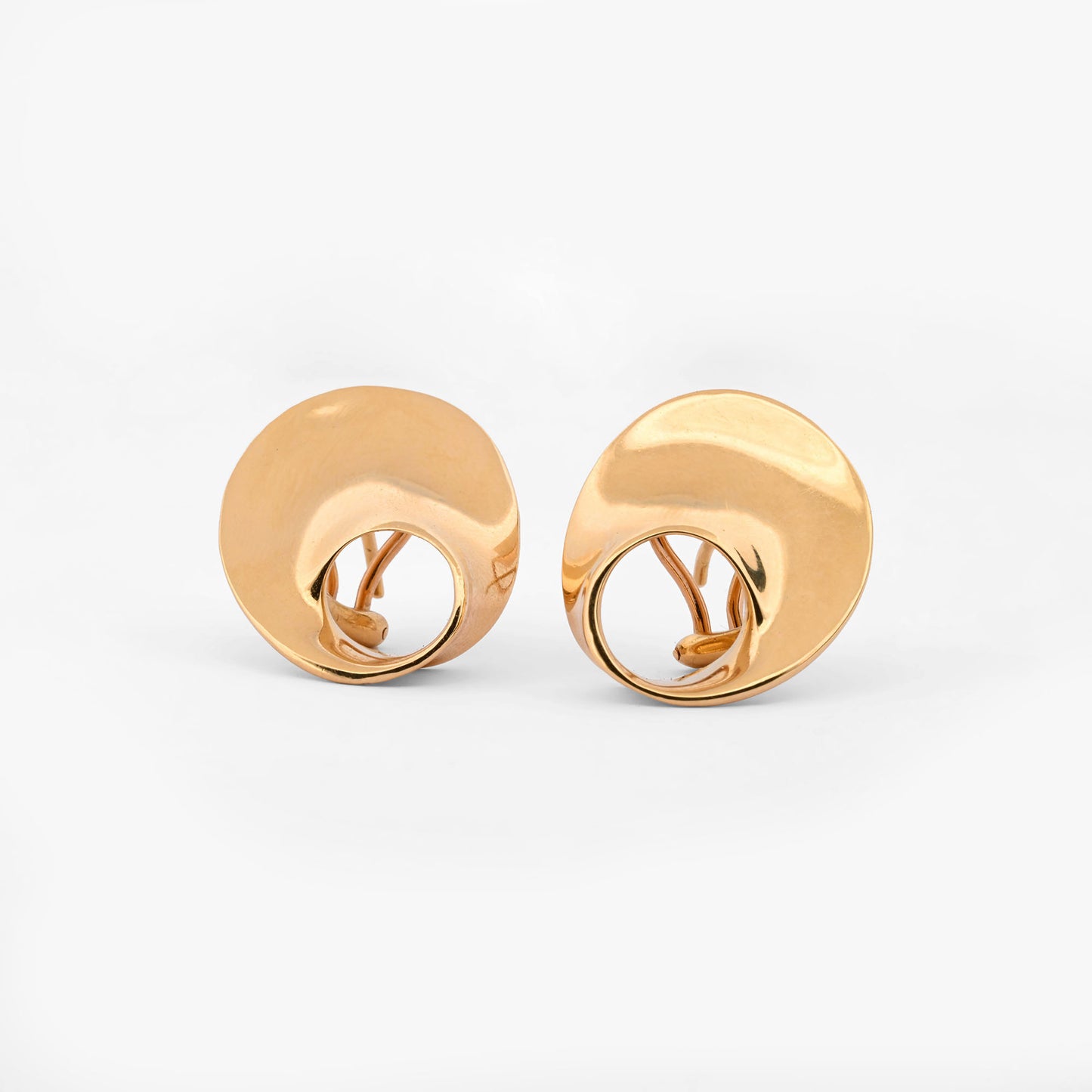 Pendientes de la marca Caparros de diseño escultural curvo con silueta calada de oro amarillo 18kt. Estos pendientes disponen de cierre tipo omega. Envío GRATIS