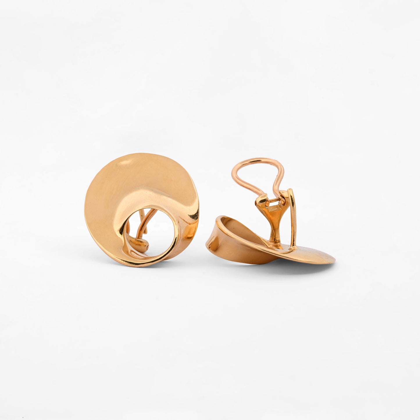Pendientes de la marca Caparros de diseño escultural curvo con silueta calada de oro amarillo 18kt. Estos pendientes disponen de cierre tipo omega. Envío GRATIS