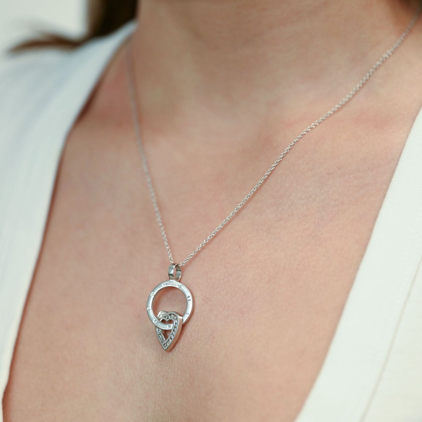 Colgante de aro calado con el nombre grabado de la firma Antonelli de oro blanco de 18kt con un motivo entrelazado de corazón. Pieza certificada y envio gratis