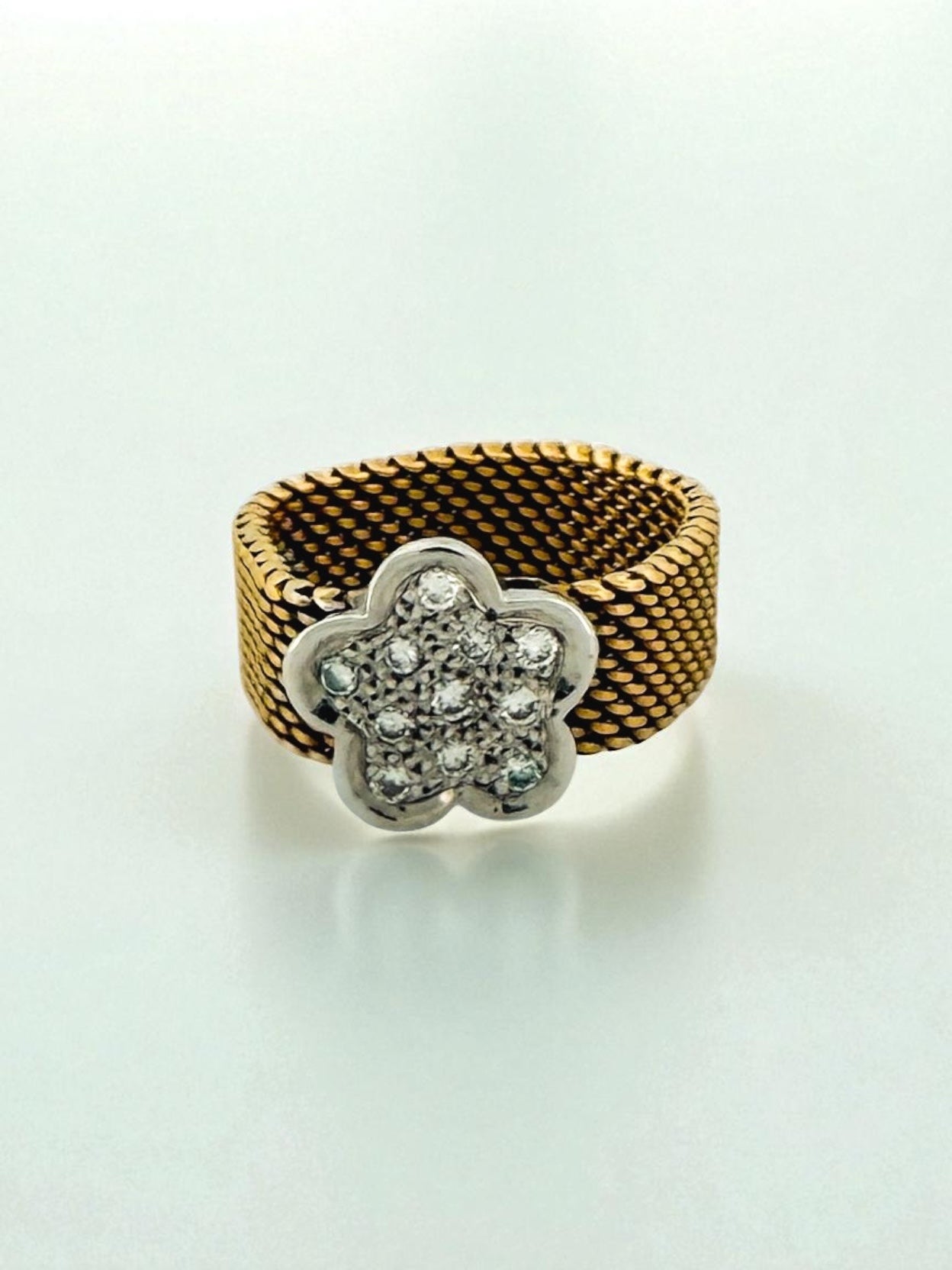 Comprar anillo original de Tous realizado con el característico tejido de malla en oro amarillo de 18kt y la flor icónica de la marca en oro amarillo de 18k. Joyas Tous baratas