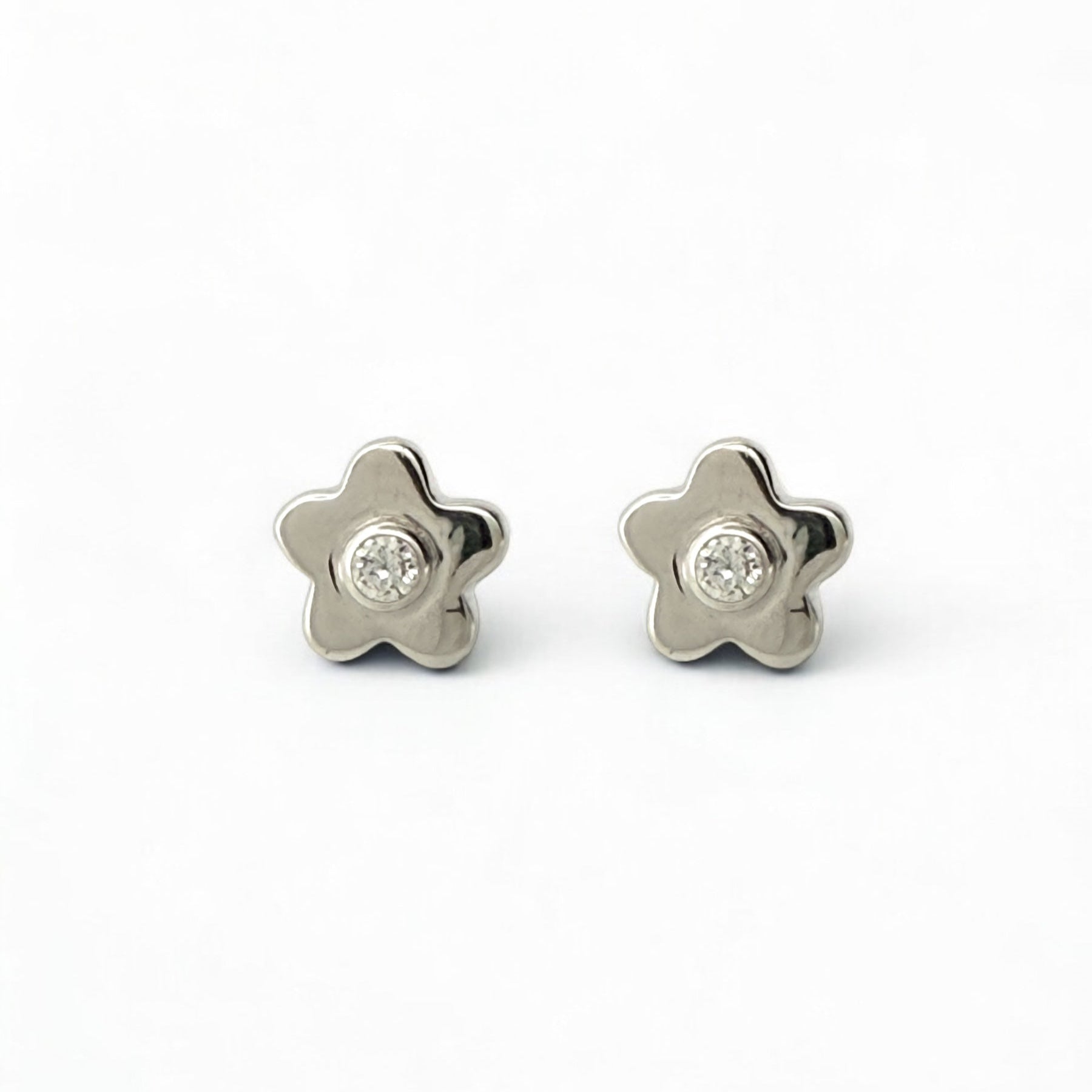 Comprar pendiente en forma de flor realizados en oro blanco de 18kt y un diamante talla brillante en cada pendiente. Pendientes oro 18kt. Envío gratis. Ian'Or.
