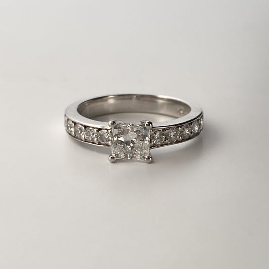 Solitario talla princesa realizado en oro blanco de 18kt y carril de 5 diamantes en cada brazo. Anillos de compromiso al mejor precio. Envío gratis. Joyería Ian'Or Barcelona