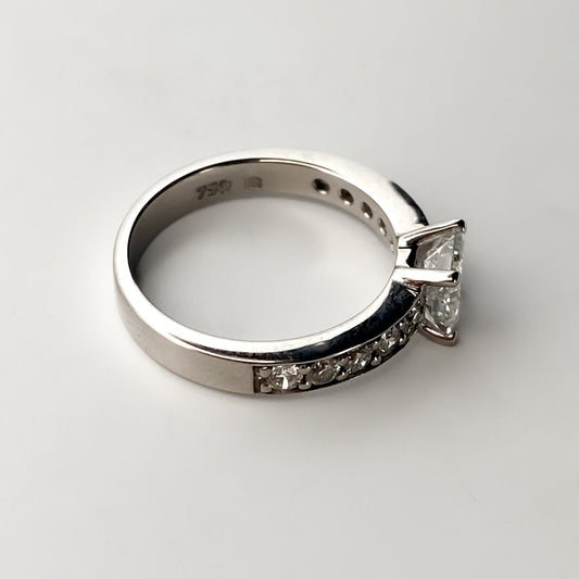 Solitario talla princesa realizado en oro blanco de 18kt y carril de 5 diamantes en cada brazo. Anillos de compromiso al mejor precio. Envío gratis. Joyería Ian'Or Barcelona