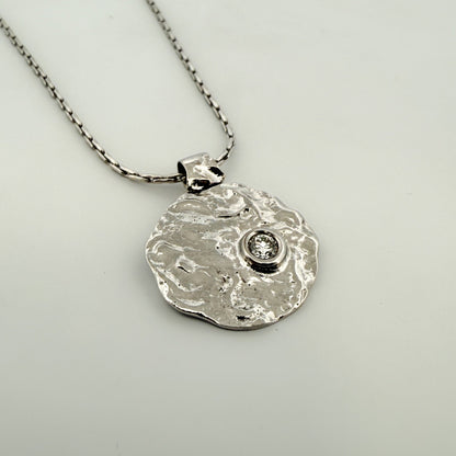 Comprar colgante en forma redondeada con textura en oro blanco de 18kt y diamante con engaste chatón. Joyería Ian'Or. Joyas restauradas. Envío gratis.

