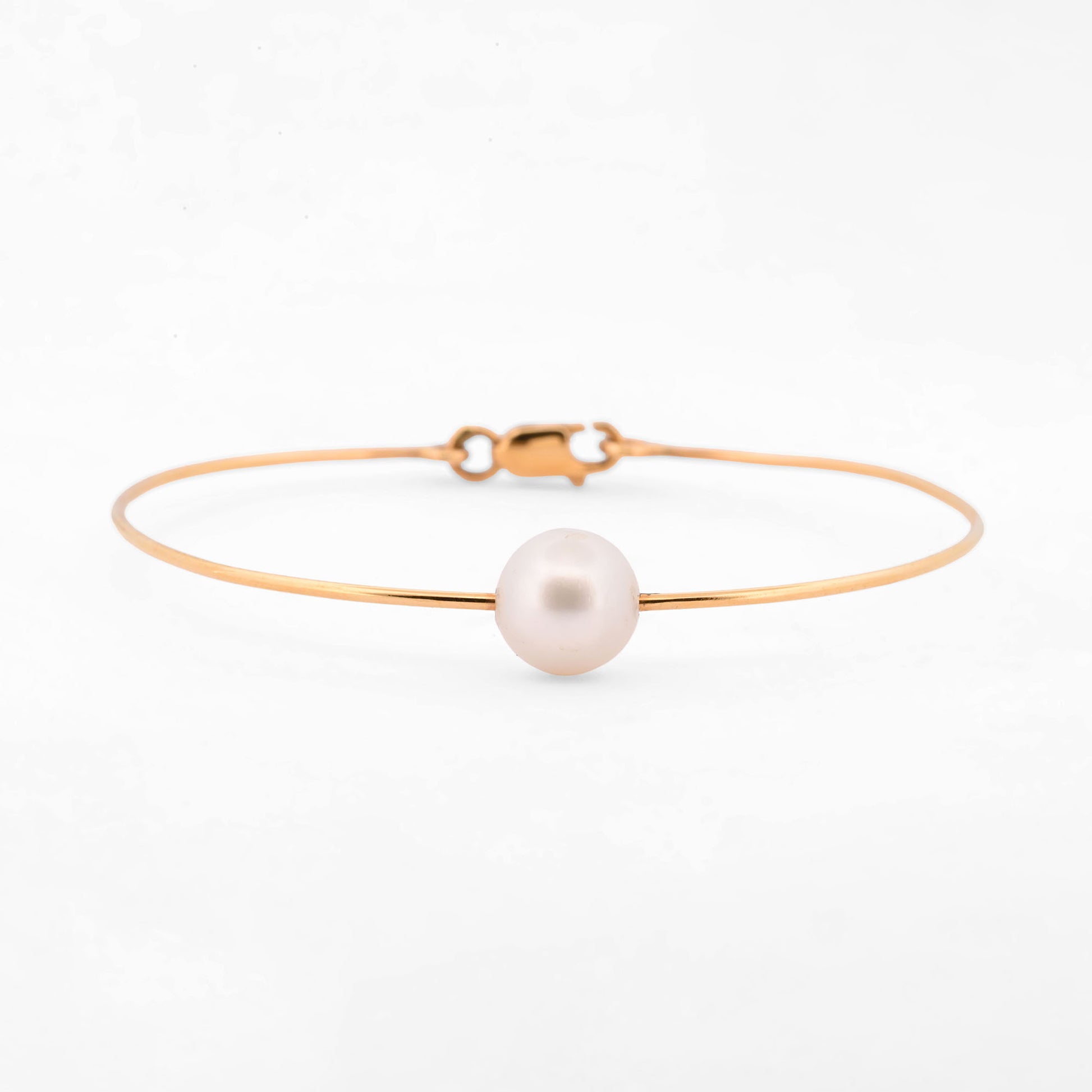 Comprar pulsera tipo esclava de oro amarillo de 18k con una perla cultivada de 9.08mm, una pieza minimalista y elegante que habla por si sola. Envío gratuito