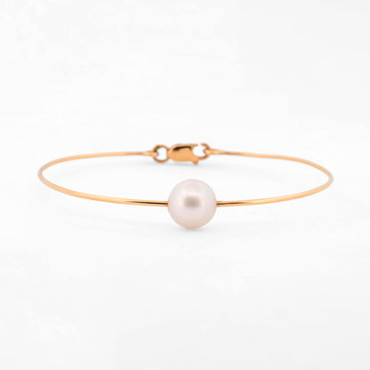 Comprar pulsera tipo esclava de oro amarillo de 18k con una perla cultivada de 9.08mm, una pieza minimalista y elegante que habla por si sola. Envío gratuito