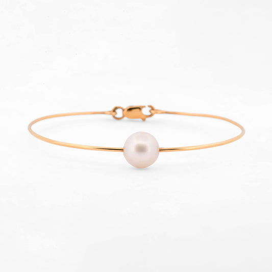 Comprar pulsera tipo esclava de oro amarillo de 18k con una perla cultivada de 9.08mm, una pieza minimalista y elegante que habla por si sola. Envío gratuito
