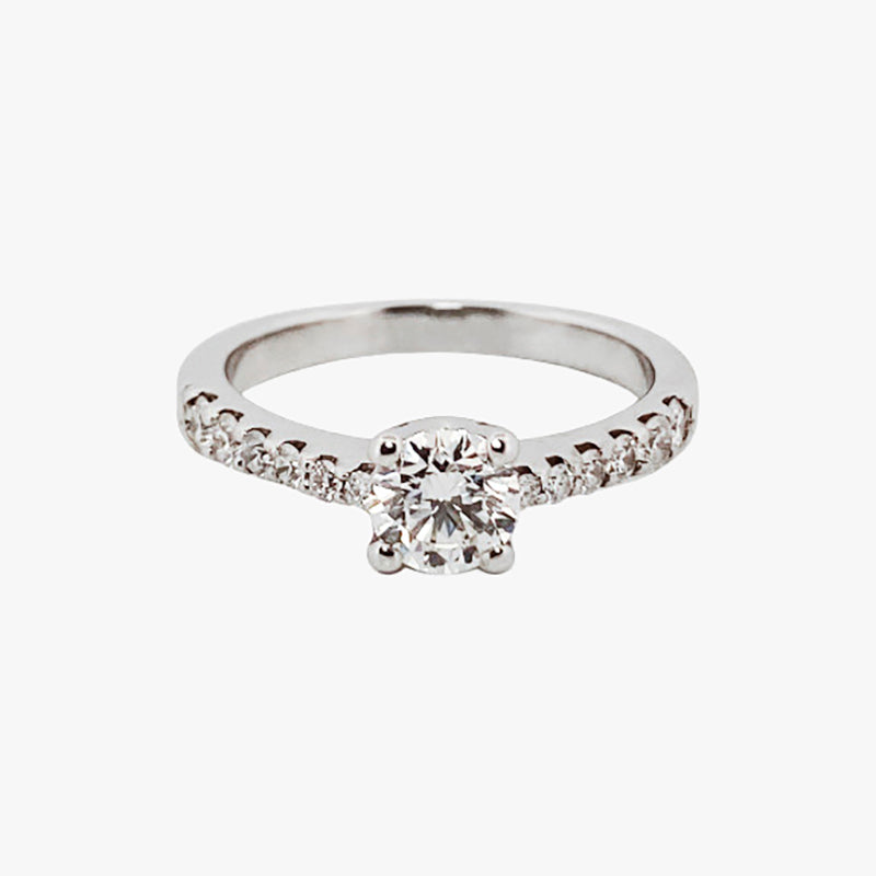 Comprar sortija en oro blanco de 18kt con rosetón de diamantes alrededor de un diamante central y carril de diamantes escalonados en brazos. Envio gratis