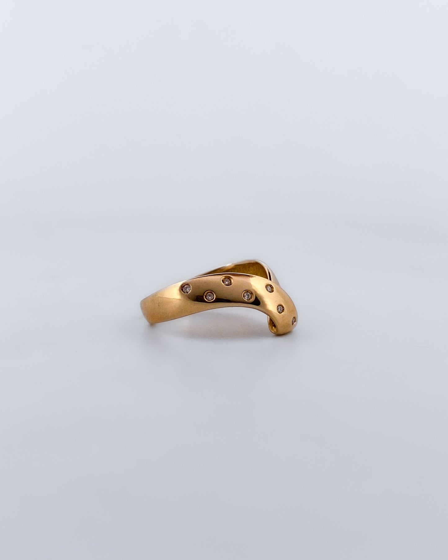 Anillo irregular realizado en oro amarillo de 18kt con 7 diamantes diamantes  pequeños a un lado del brazo. Anillos de segunda mano.