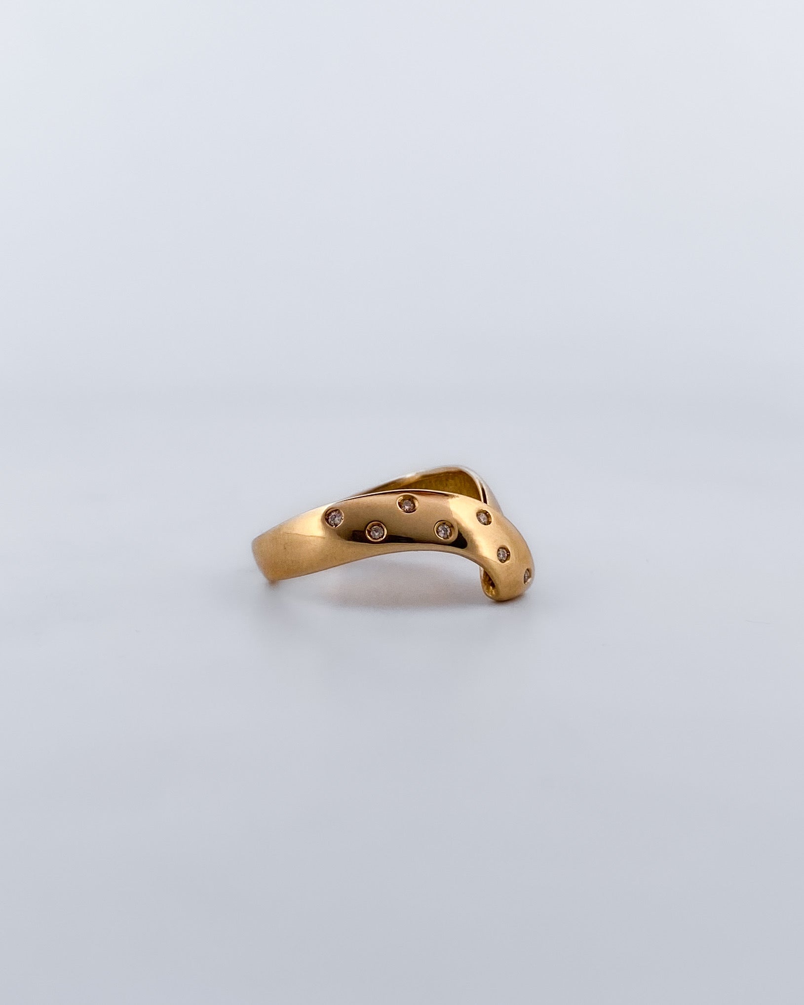 Anillo irregular realizado en oro amarillo de 18kt con 7 diamantes diamantes  pequeños a un lado del brazo. Anillos de segunda mano.
