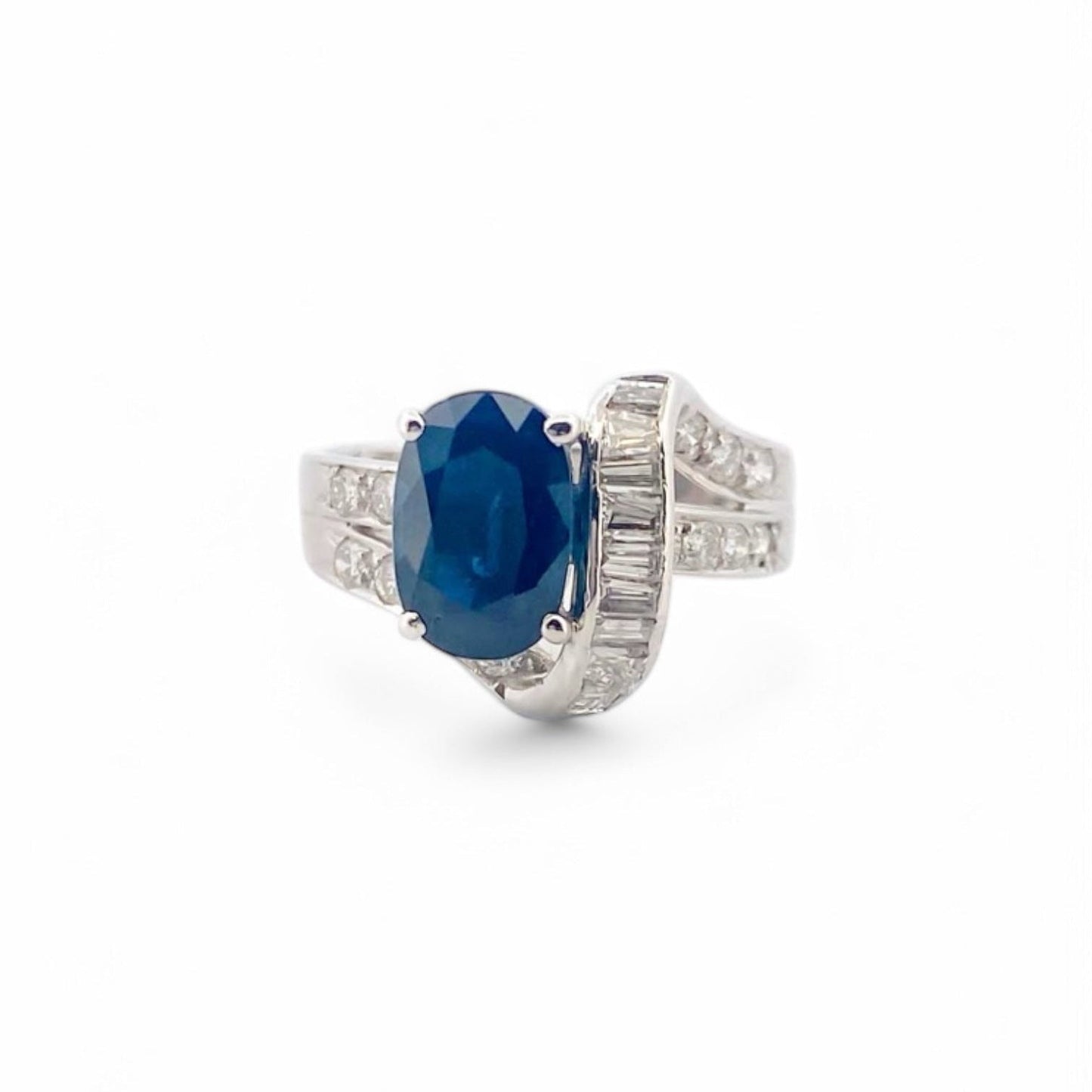 Anillo realizado en oro blanco de 18kt con un zafiro central talla oval engastado en 4 grapas y diamantes. Joyas de segunda mano Barcelona. Envío gratis.