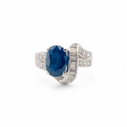 Anillo realizado en oro blanco de 18kt con un zafiro central talla oval engastado en 4 grapas y diamantes. Joyas de segunda mano Barcelona. Envío gratis.
