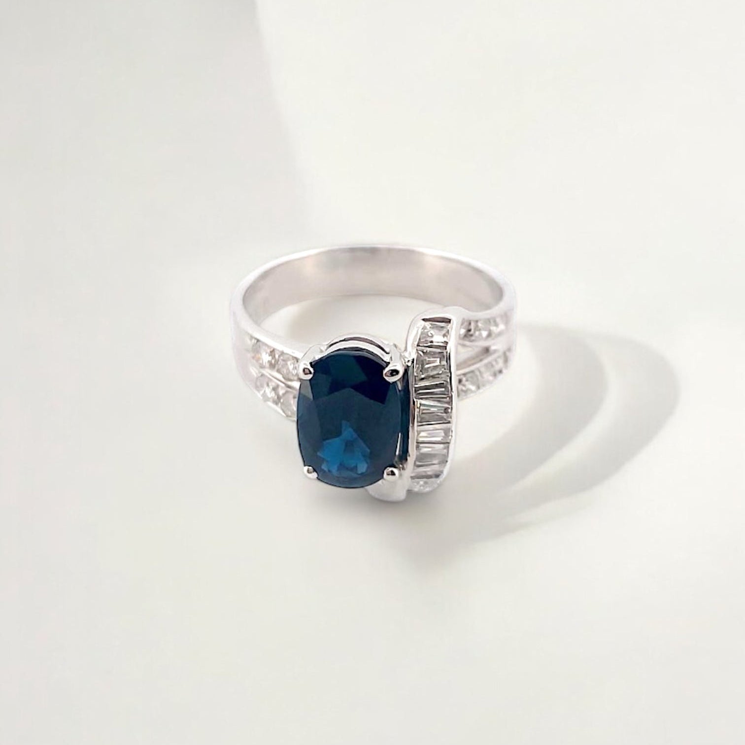 Anillo realizado en oro blanco de 18kt con un zafiro central talla oval engastado en 4 grapas y diamantes. Joyas de segunda mano Barcelona. Envío gratis.