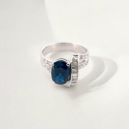 Anillo realizado en oro blanco de 18kt con un zafiro central talla oval engastado en 4 grapas y diamantes. Joyas de segunda mano Barcelona. Envío gratis.