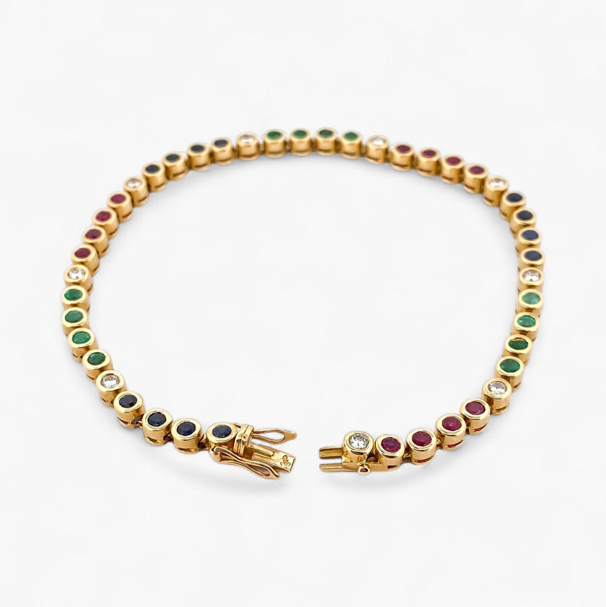 Pulsera semirígida de oro de 18kt con 3 rubíes, 3 esmeraldas y 30 zafiros azules talla princesa. Joyería Ian'Or. Joyas segunda vida. Envío GRATIS.