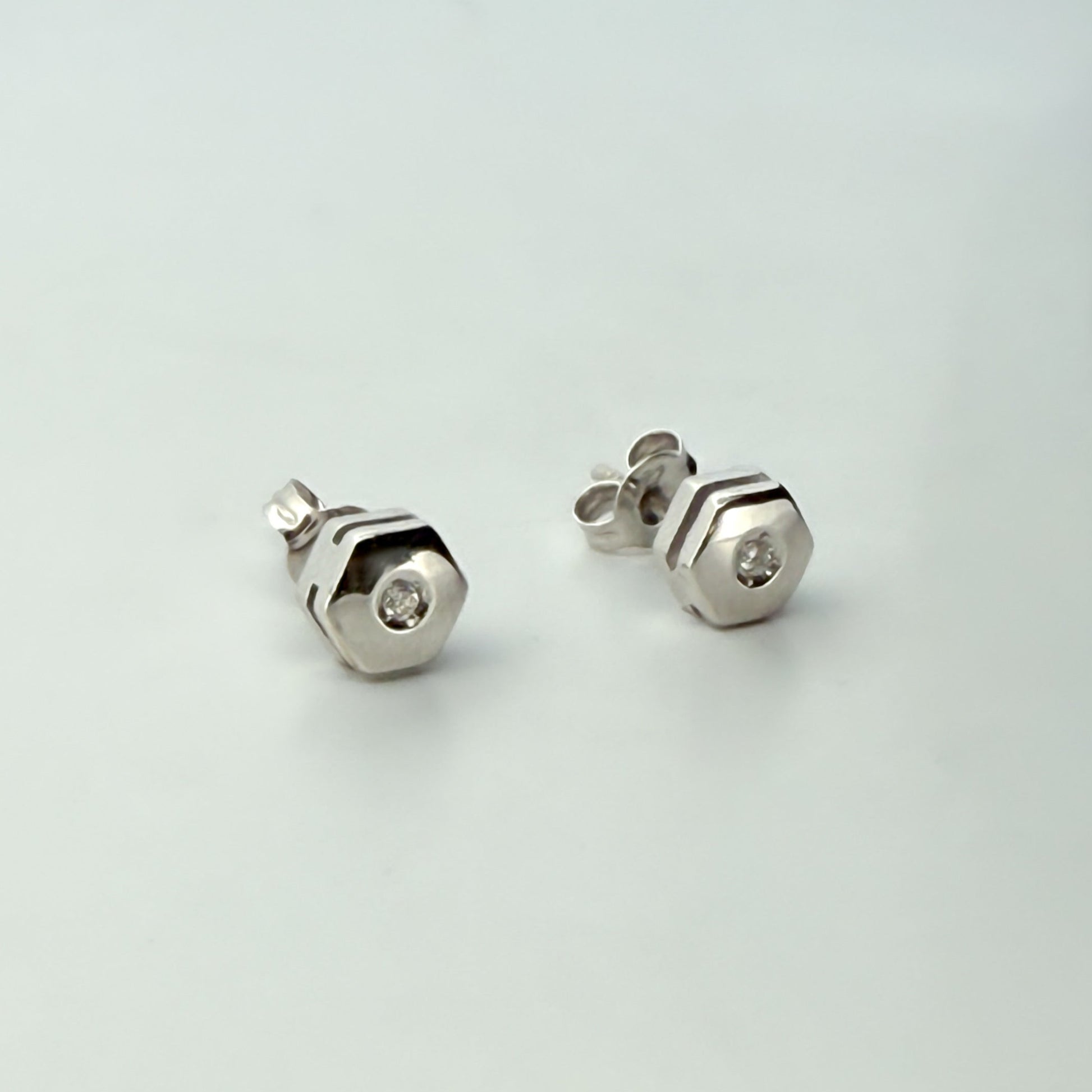 Comprar pendiente en forma de hexágono realizados en oro blanco de 18kt y un diamante talla brillante en cada pendiente. Envío gratis. Joyería Ian'Or.
