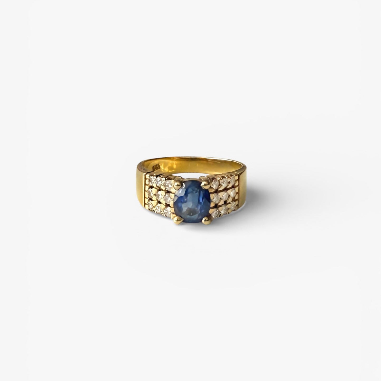 Comprar anillo realizado en oro amarillo de 18kt con un zafiro central engastado en 4 grapas y 9 diamantes cada lado. Joyas de segunda mano Barcelona. Envío gratis.