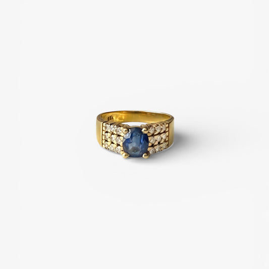 Comprar anillo realizado en oro amarillo de 18kt con un zafiro central engastado en 4 grapas y 9 diamantes cada lado. Joyas de segunda mano Barcelona. Envío gratis.