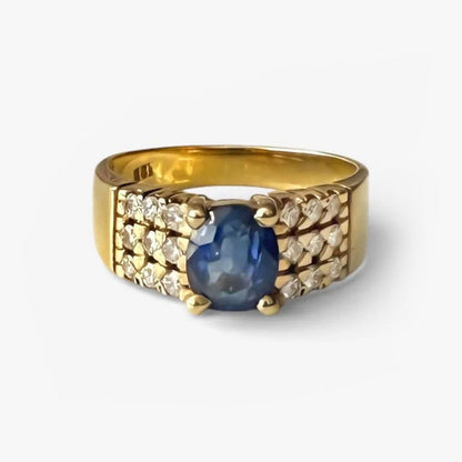 Comprar anillo realizado en oro amarillo de 18kt con un zafiro central engastado en 4 grapas y 9 diamantes cada lado. Joyas de segunda mano Barcelona. Envío gratis.