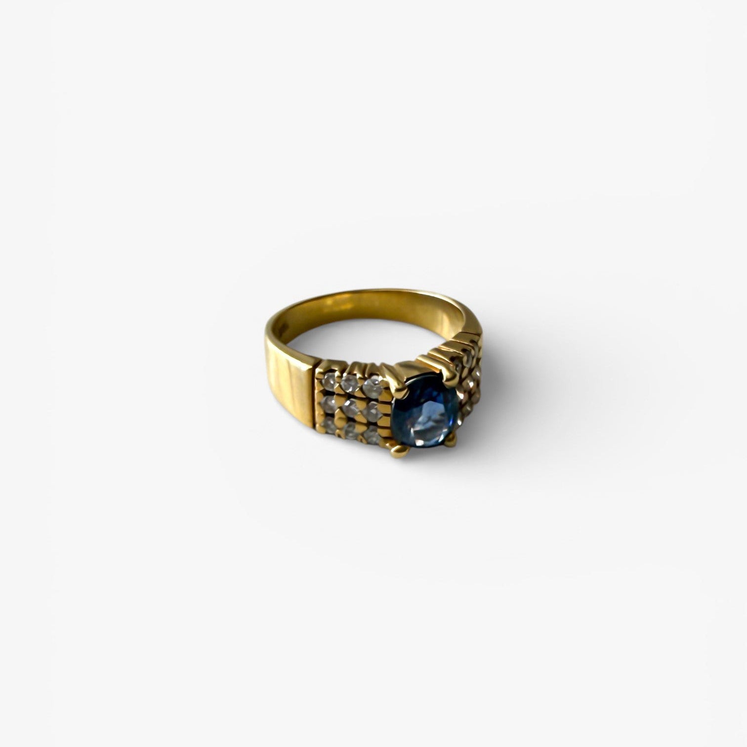 Comprar anillo realizado en oro amarillo de 18kt con un zafiro central engastado en 4 grapas y 9 diamantes cada lado. Joyas de segunda mano Barcelona. Envío gratis.