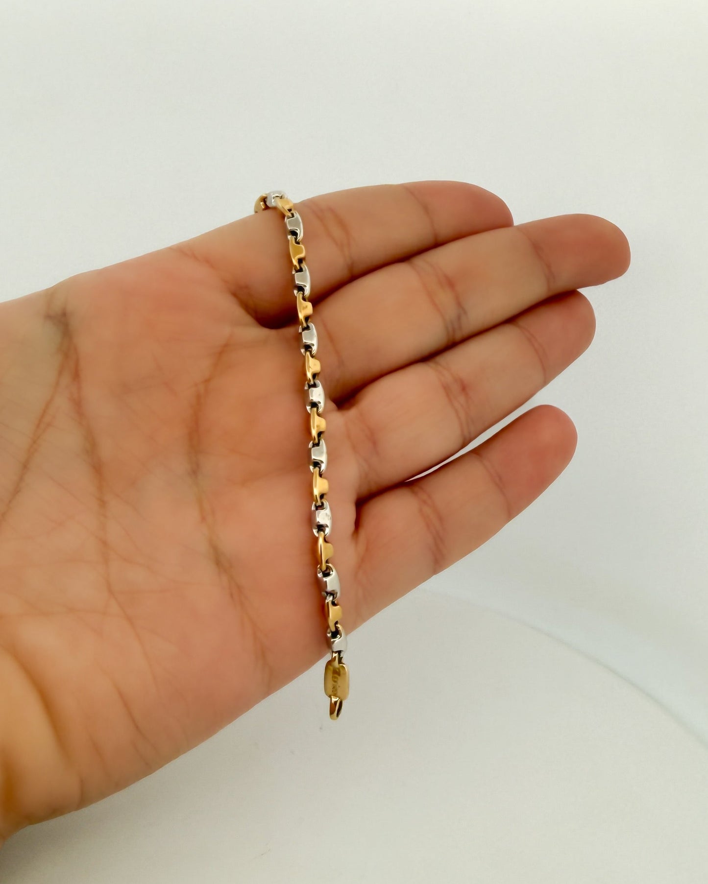 Cadena de oro blanco y amarillo alterno de 18kt con cadena diseño adige y cierre tipo mosquetón.