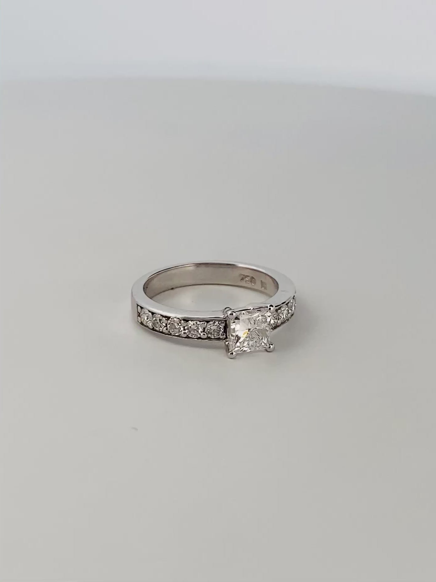 Solitario talla princesa realizado en oro blanco de 18kt y carril de 5 diamantes en cada brazo. Anillos de compromiso al mejor precio. Envío gratis. Joyería Ian'Or Barcelona